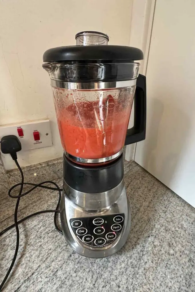 pureeing strawberry and sugar in the blender